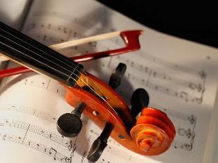 小提琴和琴弓放在乐谱上.